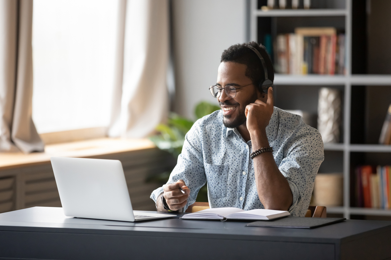 Customer service staff wearing headset looking at laptop screen